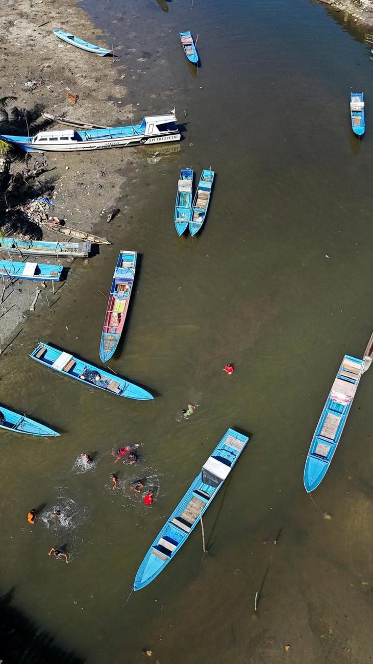 Fishing boats and kids swimming, Central Maluku