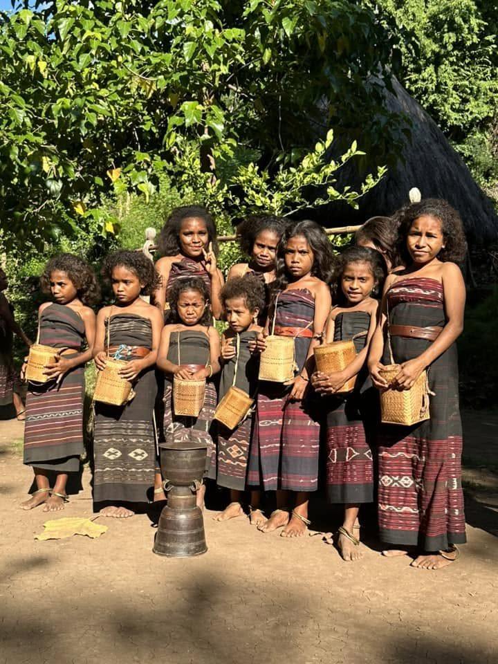 A row of girls in ikat weaving
